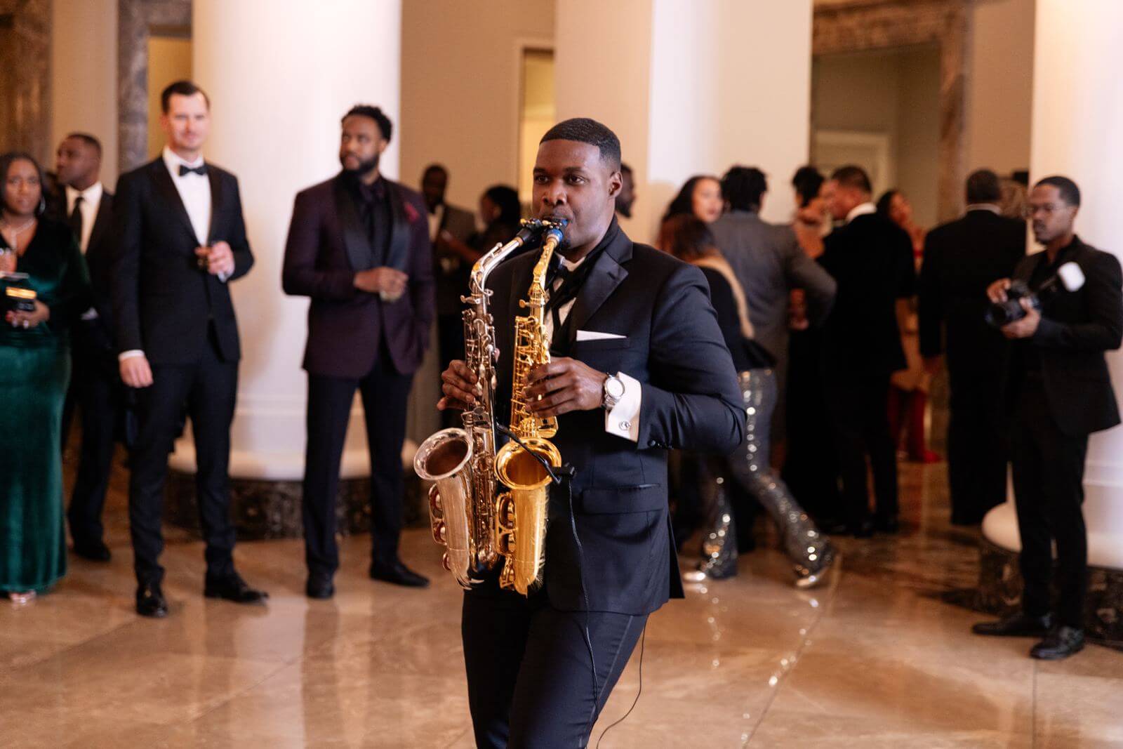 Saxophonist performing among gala guests